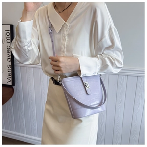 Detail of lavender lavender bucket bag with crocodile embossing and silver twist lock