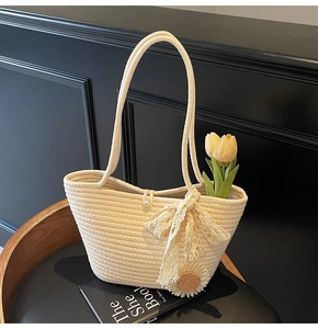 Detailed close-up of straw tote bag with sunflower patch and elegant lace bow decoration