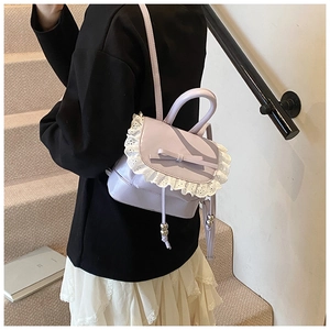 Primer plano de la mini mochila lavanda con encaje blanco y lazo llevada en la espalda