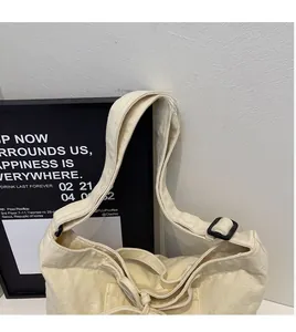 Close-up of adjustable wide shoulder strap and black buckle on beige canvas tote bag