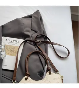 Detail of lychee textured leather bucket bag with rabbit embossing and ring handle