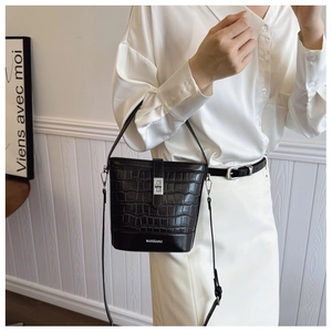 Detail of black crocodile texture bucket bag with silver twist lock and Manxiang logo