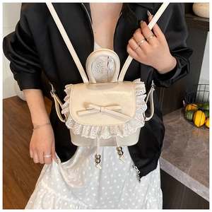 Detalle de una mini mochila beige con bordado de encaje, lazo y cierre de cordón ajustable