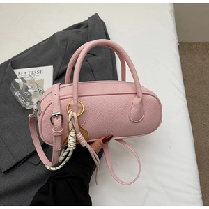 Pink lychee texture satchel held against grey suit, featuring woven rope and metallic detail