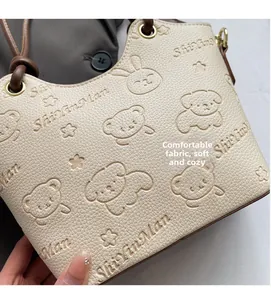 Detailed macro view of embossed leather bucket bag with cute bear and rabbit motifs