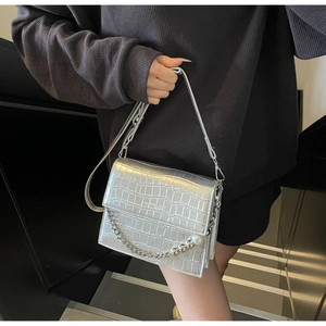 Detailed shot of silver crocodile pattern bag with metallic chain and pearl accent