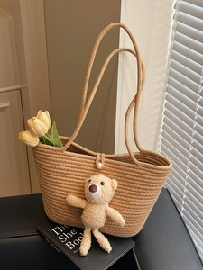 Straw woven tote bag with pearl button and cute plush bear charm for summer vacation