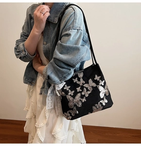 Detail of black tote with silver sequin butterflies, white lace and pearl charm