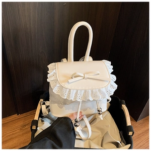 Detalle de mini mochila blanca con encaje, lazo y cordón con cuentas de metal fino
