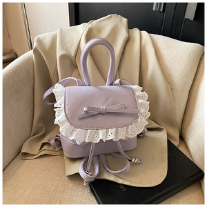 Detalle de mini mochila lavanda con encaje blanco y lazo delicado en acabado de cuero