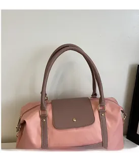 Détail du sac cabas en nylon rose avec poignées en cuir marron et détails en métal doré