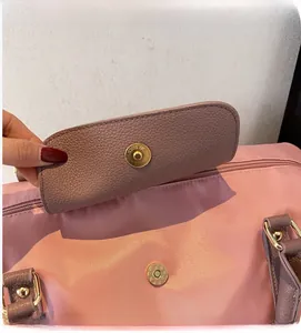 Détail du sac cabas rose avec fermeture magnétique dorée et texture en tissu résistant