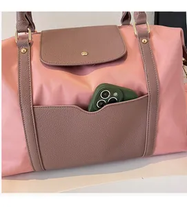 Détail des poches avant du sac fourre-tout rose montrant le rangement du smartphone