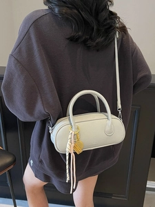 Chic light sage green pebble leather boston bag with detachable strap and tassel charm