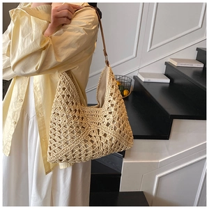 Detail of hand-woven beige crochet bag with textured pattern and slim brown handles