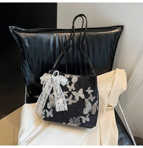 Detail of black tote with silver butterfly sequins and lace bow with pearl charm