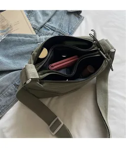 Internal view of olive green canvas crossbody bag showing multi-zipper layers and large capacity