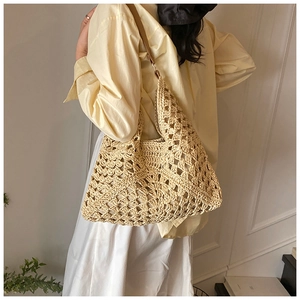 Detail of handmade hollow crochet tote bag with elegant beige diamond weave patterns