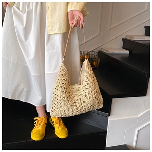 Close-up of cream crochet tote bag with brown leather strap in a lifestyle scene