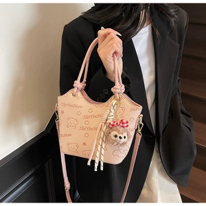 Detail of pink bucket bag with cute cartoon bear print and stylish plush pendant charm