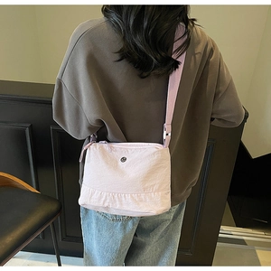 Back view of a light purple waterproof nylon crossbody bag with adjustable wide strap