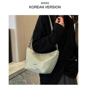 Detail of light green crescent underarm bag with silver chain strap and logo