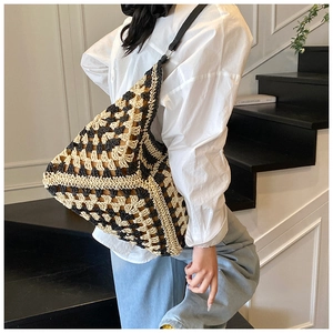 Close-up of geometric knit shoulder bag with woven texture and leather strap details