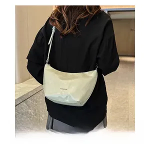 Close-up of mint green hobo bag with Loverman logo worn with black shirt