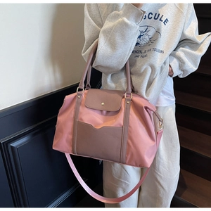 Détail du grand sac cabas en nylon rose et violet avec rabat en cuir porté par un mannequin