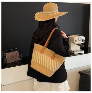 Close-up of woven straw tote bag with white stripes and matching beach sun hat