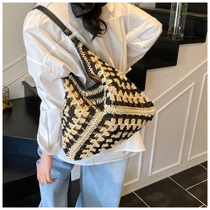 Close-up of geometric woven tote bag with leather strap on model for summer beach fashion