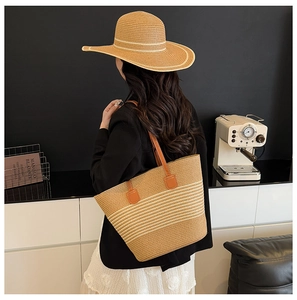 Large straw tote bag with brown leather handles styled with a matching wide brim sun hat