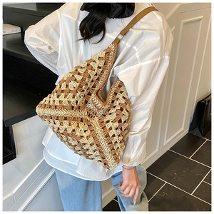 Detail of checkered crochet hobo bag with brown leather strap worn by a model