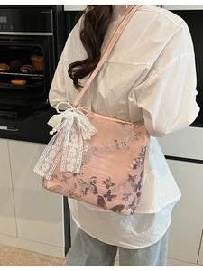 Pink sequin butterfly tote bag with white lace bow and pearl tassels on model's shoulder