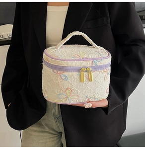 Detail der süßen Kosmetiktasche mit Stickerei, goldenem Reißverschluss und lila Rand