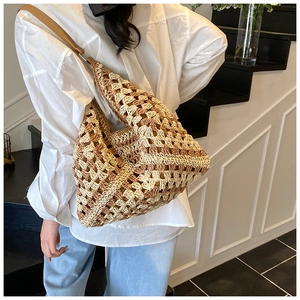Macro detail of hand-woven geometric straw shoulder bag with leather strap in use