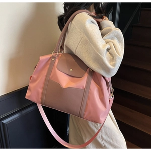 Détail du sac fourre-tout en nylon rose et cuir marron avec bandoulière et rabat avant