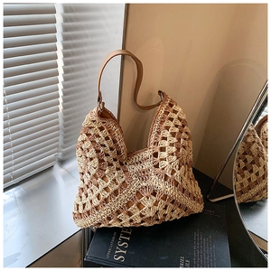 Close-up of hand-crocheted hollow diamond pattern and brown leather strap on summer bag