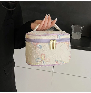 Detailansicht der gesteppten Kosmetiktasche mit Schleifenstickerei und lila Zipper