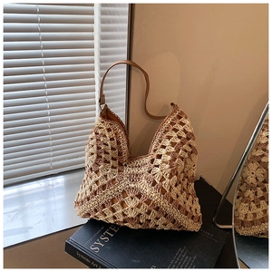 Detailed macro of hollow-out crochet pattern on beige woven straw beach shoulder bag