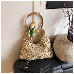 Detailed close-up of handmade woven straw bag with hollow texture and leather handle