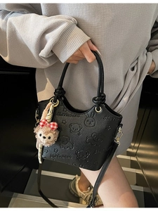 Vintage black leather bucket bag with embossed cartoon bear and plush charm on hand