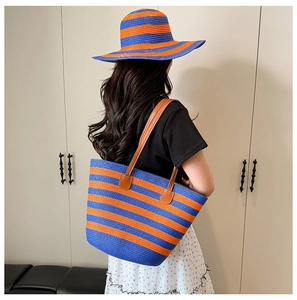 Matching set of large straw tote bag and sun hat with blue and orange stripes for summer