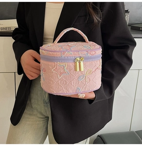 Detailansicht der rosa Kosmetiktasche mit Gold-Reißverschluss und Sternenbestickung
