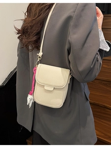 Petit sac bandoulière beige pour téléphone avec texture grainée et breloque mignonne