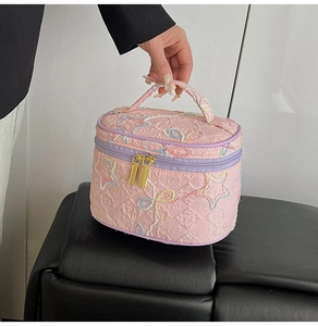 Detailaufnahme der rosa gesteppten Kosmetiktasche mit bunter Sternstickerei und Reißverschluss