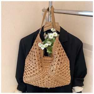 Detailed macro view of hollow-out woven straw bag texture with a brown leather strap