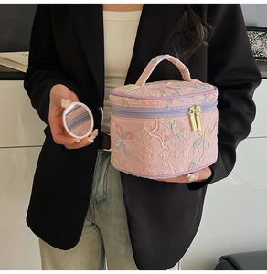 Details der rosa bestickten zylindrischen Kosmetiktasche mit Sternenmuster und Griff