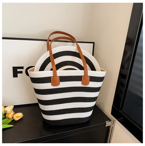 Detail of striped woven straw tote bag with matching hat and brown leather handles