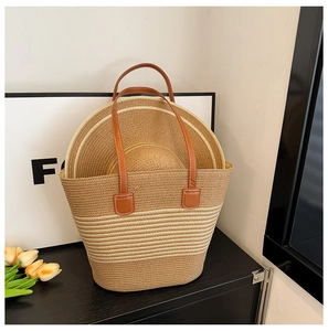 Detail of large woven straw tote bag and matching sun hat with leather handles